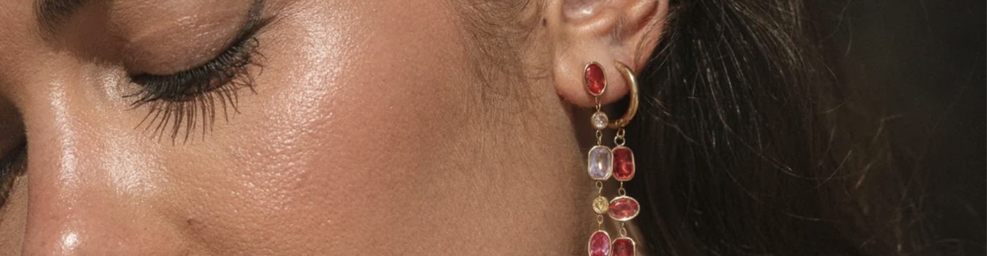 Model mit langen Ohrhängern und geschlossenen Augen